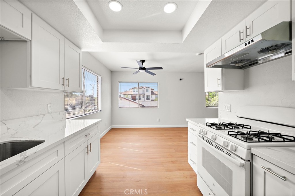 This galley-style kitchen offers generous counter space and a bright connection to the adjoining dining area. - 9941 11th Street, Garden Grove CA 92844 - photo 15