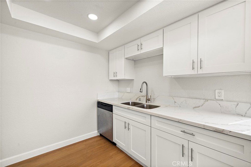 White cabinetry and light quartz counters surround the kitchen sink for a crisp, updated workspace. - 9941 11th Street, Garden Grove CA 92844 - photo 16