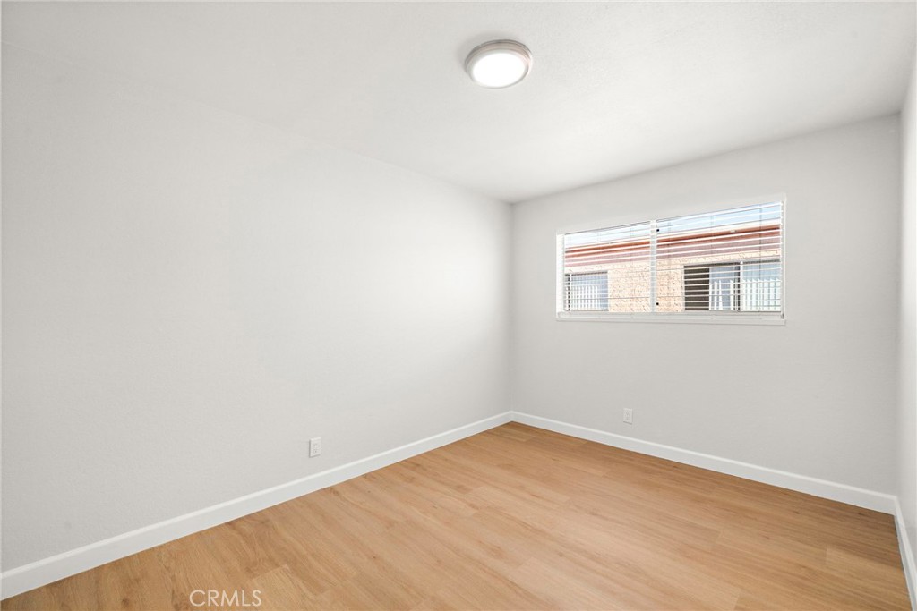 This bright bedroom features wood-look flooring, fresh white walls, and a window that welcomes natural light. - 9941 11th Street, Garden Grove CA 92844 - photo 18