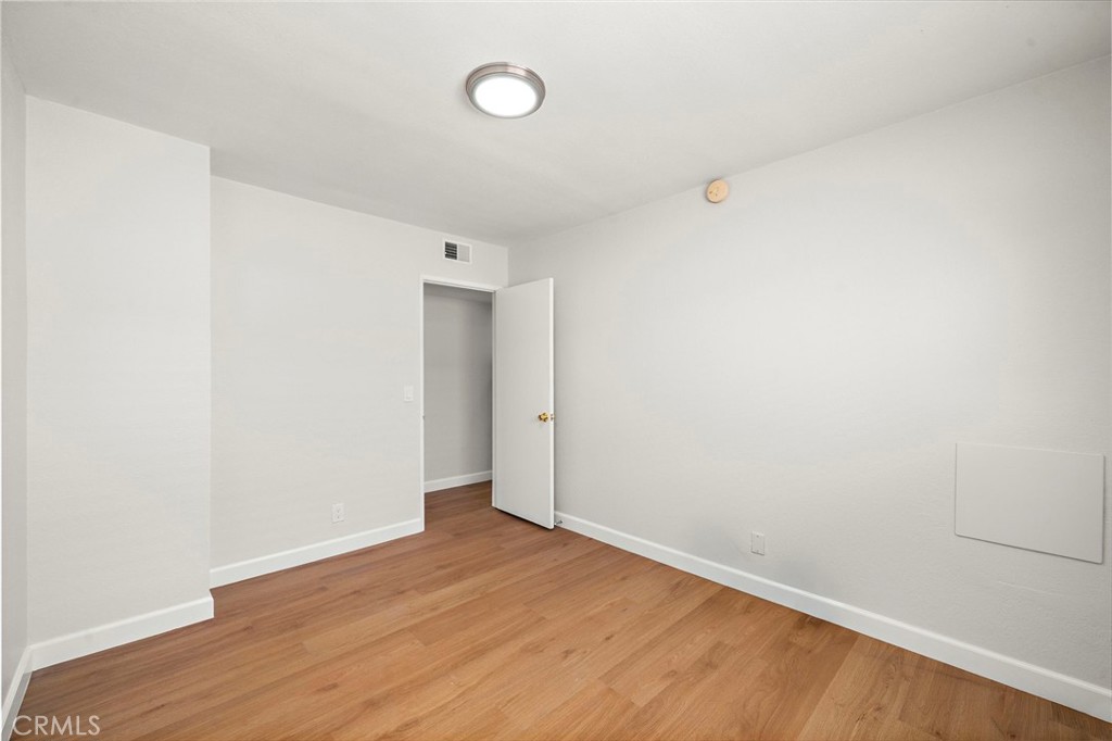 Fresh white walls and warm wood-look flooring give this bedroom a clean, versatile setting. - 9941 11th Street, Garden Grove CA 92844 - photo 22