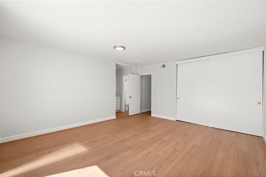 This expansive room offers wood-look flooring, abundant open space, and a wide sliding-door closet. - 9941 11th Street, Garden Grove CA 92844 - photo 25