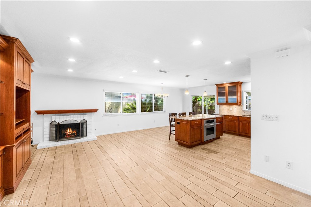 Bright open living area featuring wood-style flooring, recessed lighting, and abundant natural light. - 17042 Friml Lane, Huntington Beach CA 92649 - photo 5