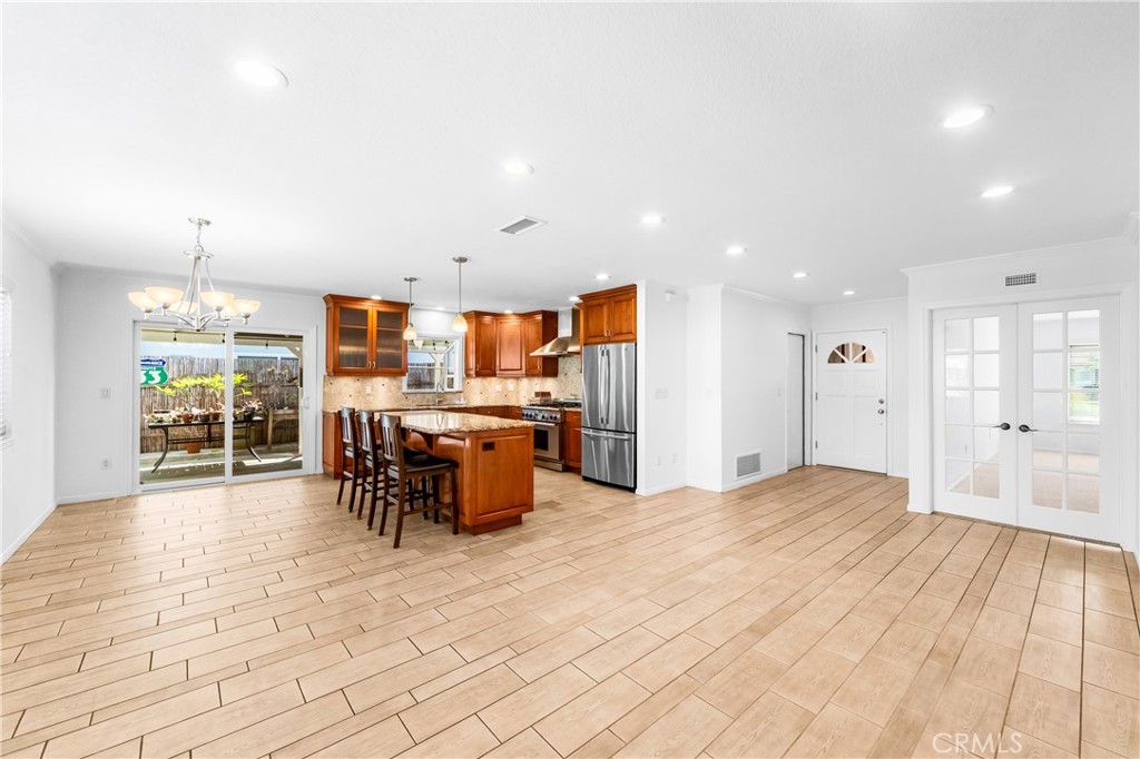 Open-concept kitchen and living area with a large center island and generous cabinet storage. - 17042 Friml Lane, Huntington Beach CA 92649 - photo 6