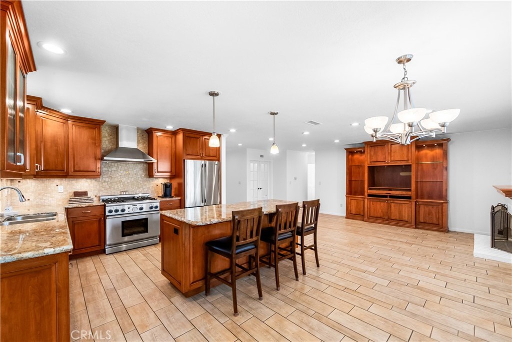 Spacious kitchen featuring wood cabinetry, center island, and adjoining dining area. - 17042 Friml Lane, Huntington Beach CA 92649 - photo 7
