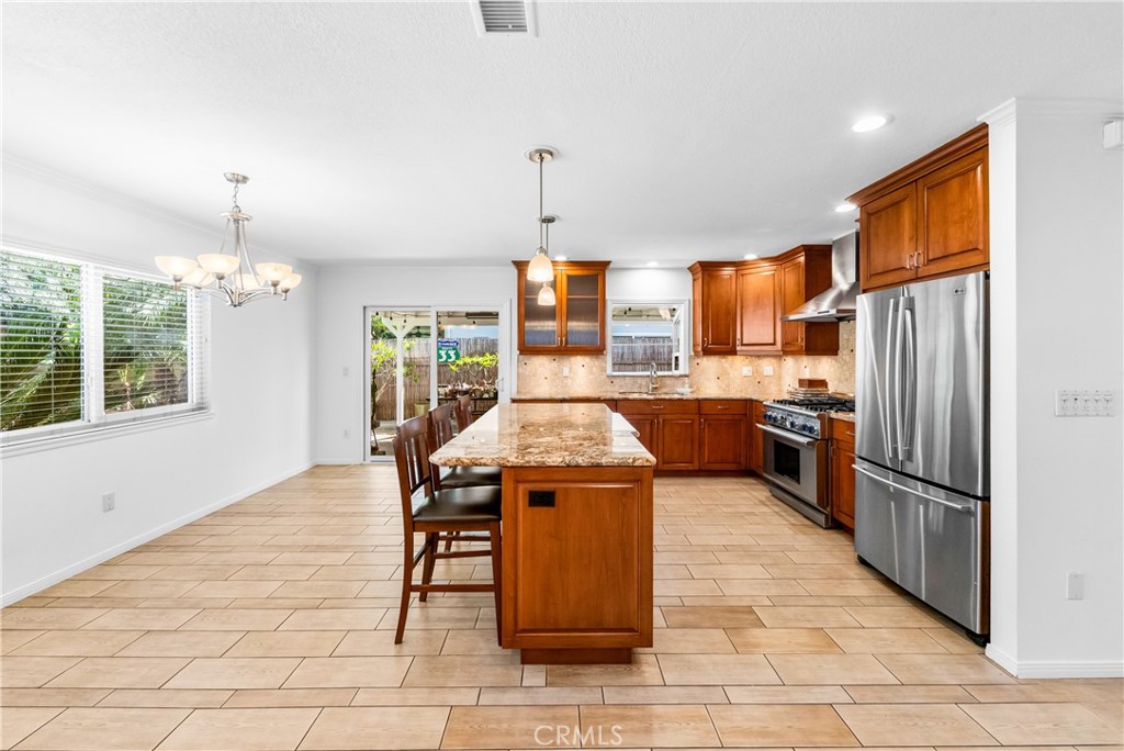 Open kitchen showcasing generous counter space, cabinetry, and center island. - 17042 Friml Lane, Huntington Beach CA 92649 - photo 11