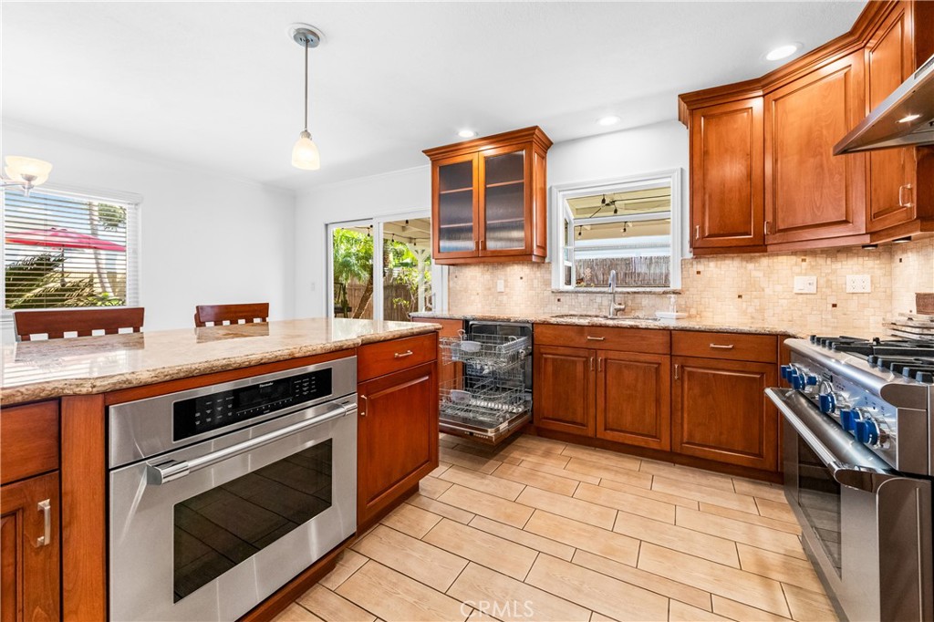 Well-equipped kitchen with extensive cabinetry, counter space, and stainless-steel appliances. - 17042 Friml Lane, Huntington Beach CA 92649 - photo 14