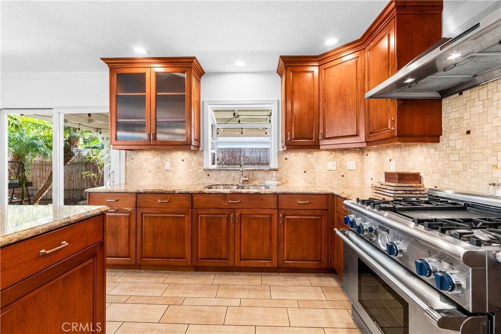 Spacious kitchen featuring wood cabinetry, center island, and stainless-steel appliances. - 17042 Friml Lane, Huntington Beach CA 92649 - photo 15