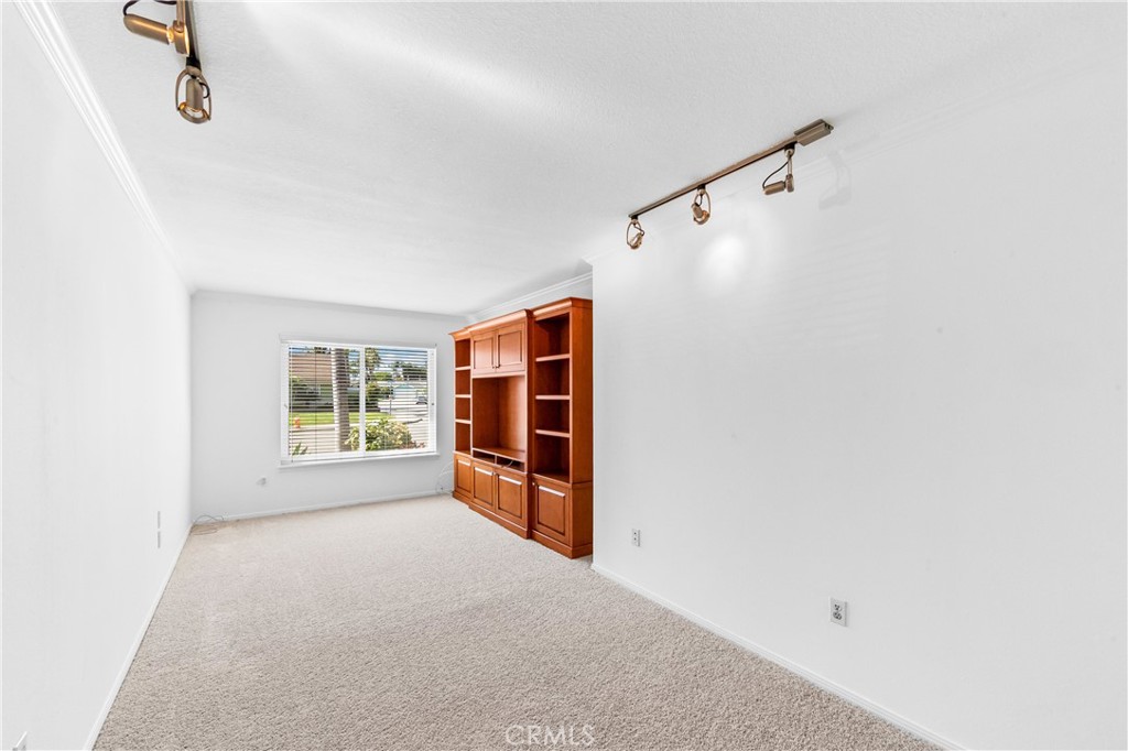 Light-filled bedroom 1 with new paint and new carpet flooring, recessed lighting, and large window. - 17042 Friml Lane, Huntington Beach CA 92649 - photo 18