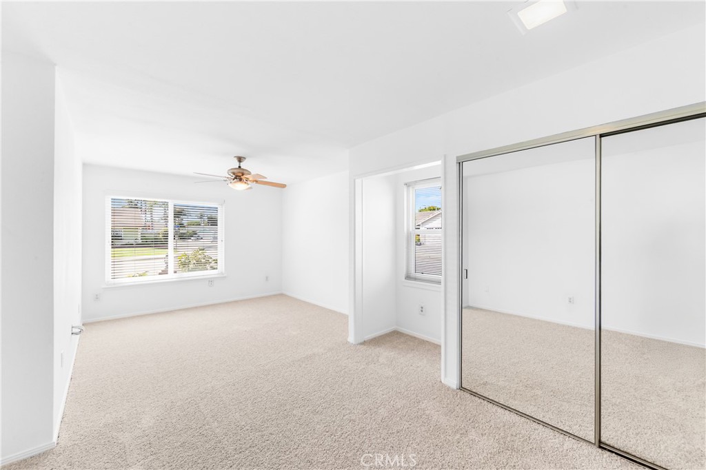 Spacious bedroom 2 with windows giving ample natural light, and generous closet space. - 17042 Friml Lane, Huntington Beach CA 92649 - photo 23