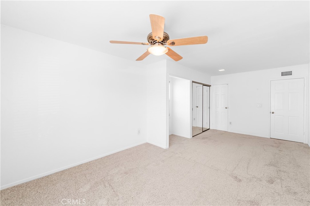Bright bedroom 2 featuring a ceiling fan, recessed lighting, new paint, new carpet flooring. - 17042 Friml Lane, Huntington Beach CA 92649 - photo 24