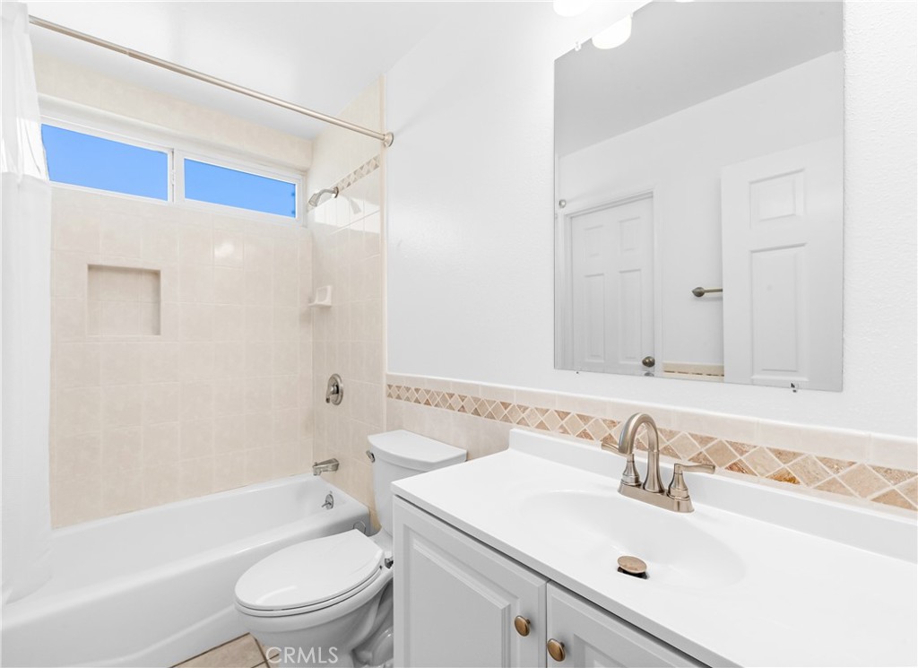 Guest bathroom with vanity, tub/shower combination, and ample storage. - 17042 Friml Lane, Huntington Beach CA 92649 - photo 27