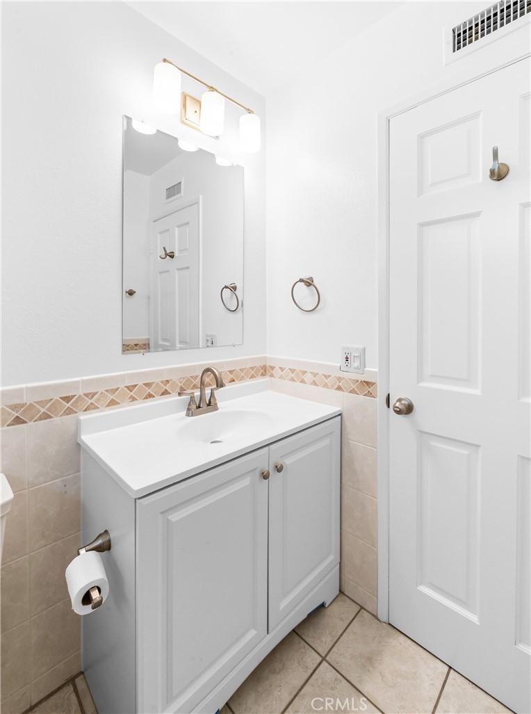 Updated-looking bathroom with vanity, storage, and bright finishes. - 17042 Friml Lane, Huntington Beach CA 92649 - photo 29