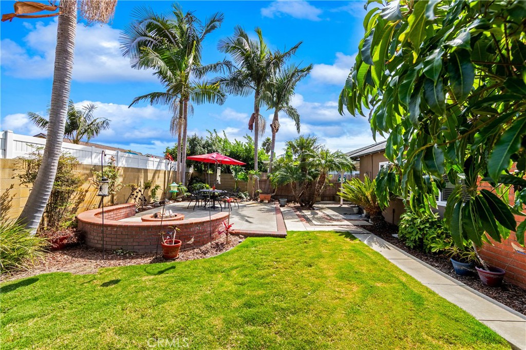 Expansive backyard with patio, lawn area, and mature landscaping. - 17042 Friml Lane, Huntington Beach CA 92649 - photo 39
