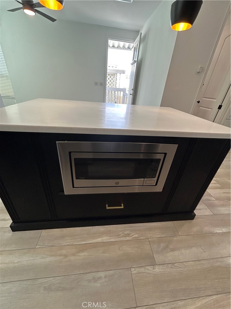 kitchen island with built in microwave - 17261 Gothard Street 13, Huntington Beach CA 92647 - photo 10