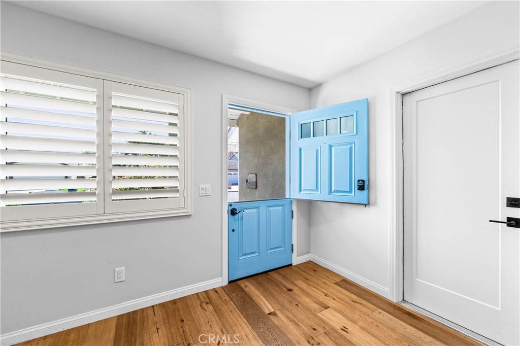 Light-filled living space with warm wood flooring and plantation shutters. - 17327 Apel Lane, Huntington Beach CA 92649 - photo 3