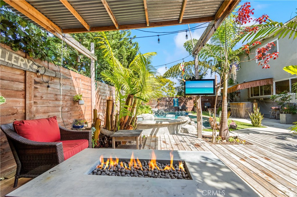 Covered outdoor entertaining area overlooking the pool and tropical landscaping. - 17327 Apel Lane, Huntington Beach CA 92649 - photo 5
