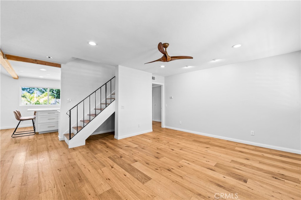 Spacious great room with wood flooring, ceiling fan and abundant natural light. - 17327 Apel Lane, Huntington Beach CA 92649 - photo 8