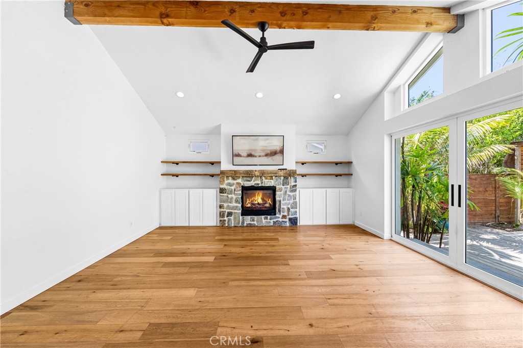Elegant dining and living area with wood flooring and views toward the tropical backyard. - 17327 Apel Lane, Huntington Beach CA 92649 - photo 9