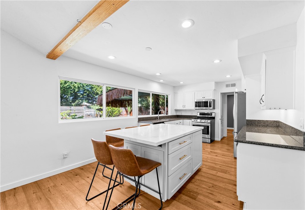 Gourmet kitchen featuring a large island, stainless-steel appliances and abundant cabinetry. - 17327 Apel Lane, Huntington Beach CA 92649 - photo 12