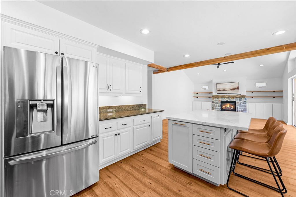 Upscale kitchen with generous island seating and modern stainless-steel appliances. - 17327 Apel Lane, Huntington Beach CA 92649 - photo 13