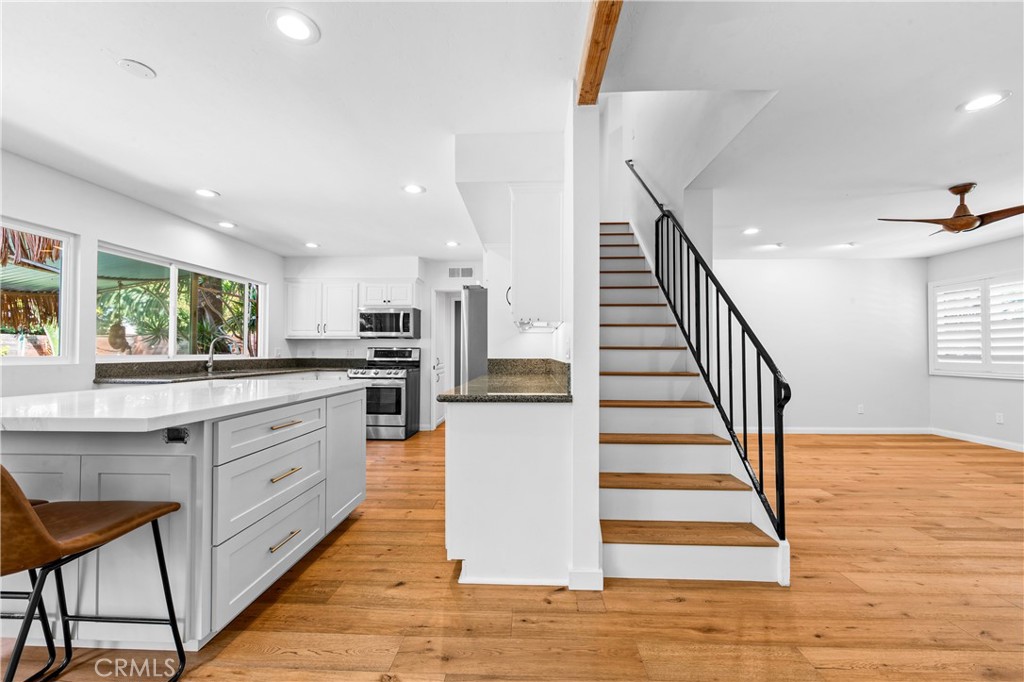 Open kitchen and dining area with island seating and a bright, welcoming layout. - 17327 Apel Lane, Huntington Beach CA 92649 - photo 16