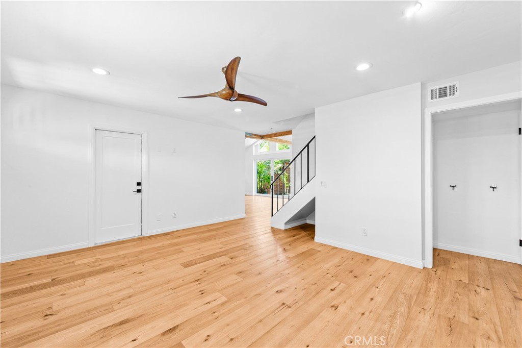 Spacious living area with wood flooring, ceiling fan and clean contemporary finishes. - 17327 Apel Lane, Huntington Beach CA 92649 - photo 20