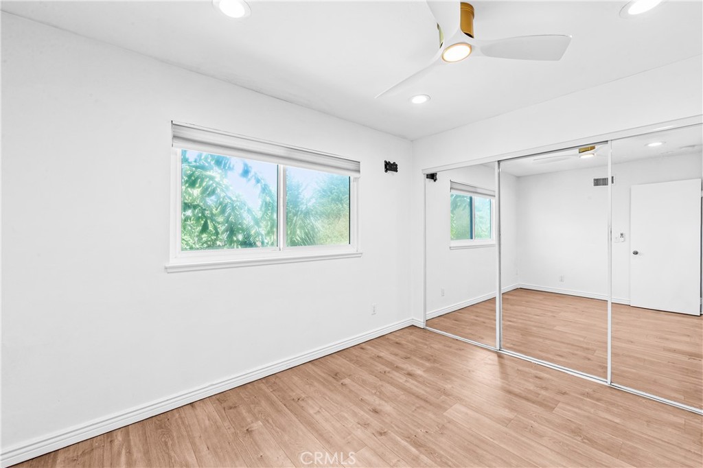 Inviting bedroom with wood flooring, ceiling fan and generous natural light. - 17327 Apel Lane, Huntington Beach CA 92649 - photo 22