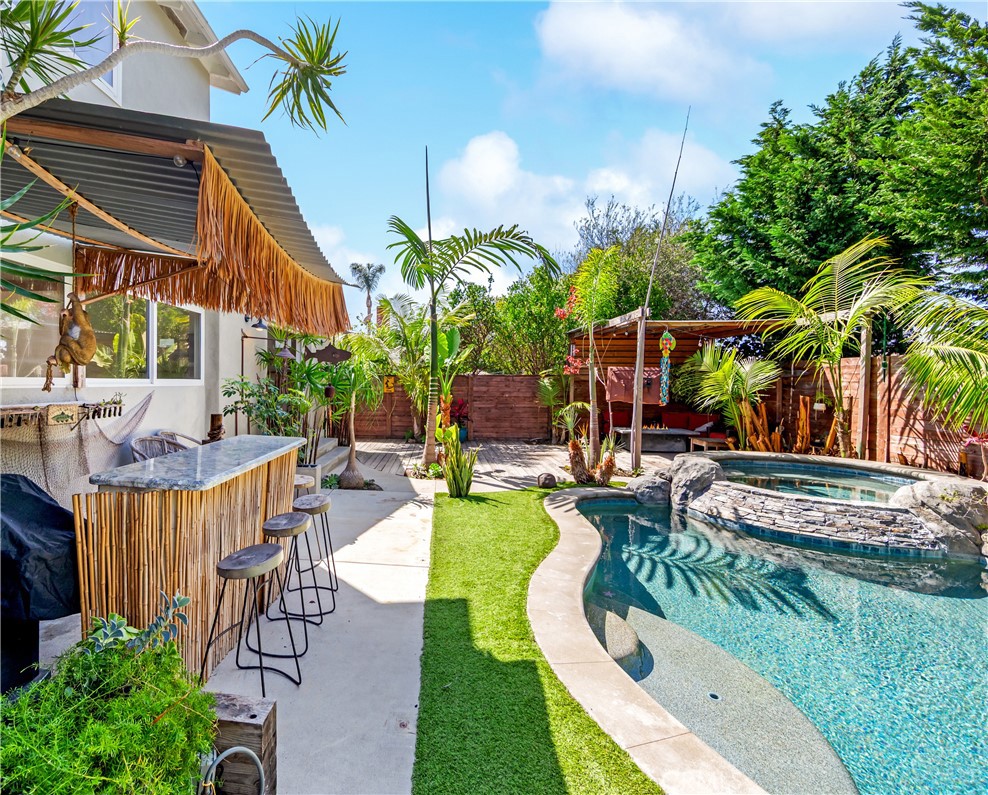 Lush tropical landscaping surrounds the pool and creates an inviting outdoor setting. - 17327 Apel Lane, Huntington Beach CA 92649 - photo 24