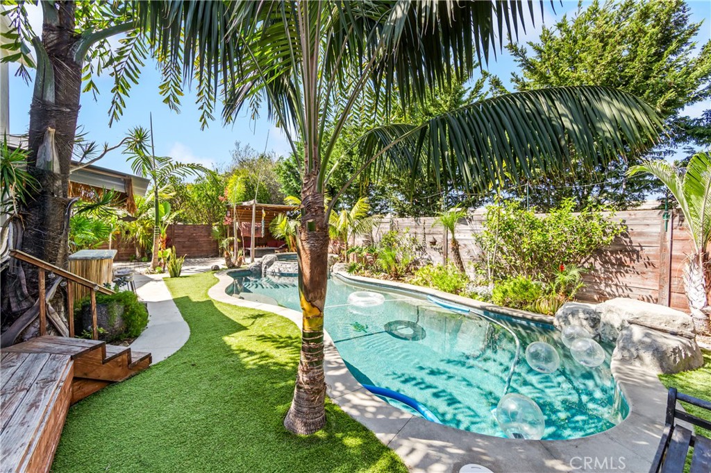 Serene poolside setting with mature landscaping and multiple areas for relaxation. - 17327 Apel Lane, Huntington Beach CA 92649 - photo 25