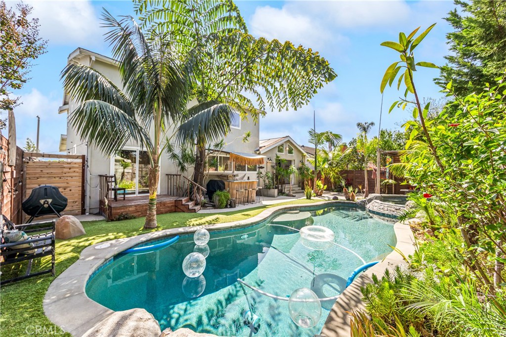 Sparkling pool surrounded by tropical greenery for effortless outdoor enjoyment. - 17327 Apel Lane, Huntington Beach CA 92649 - photo 26