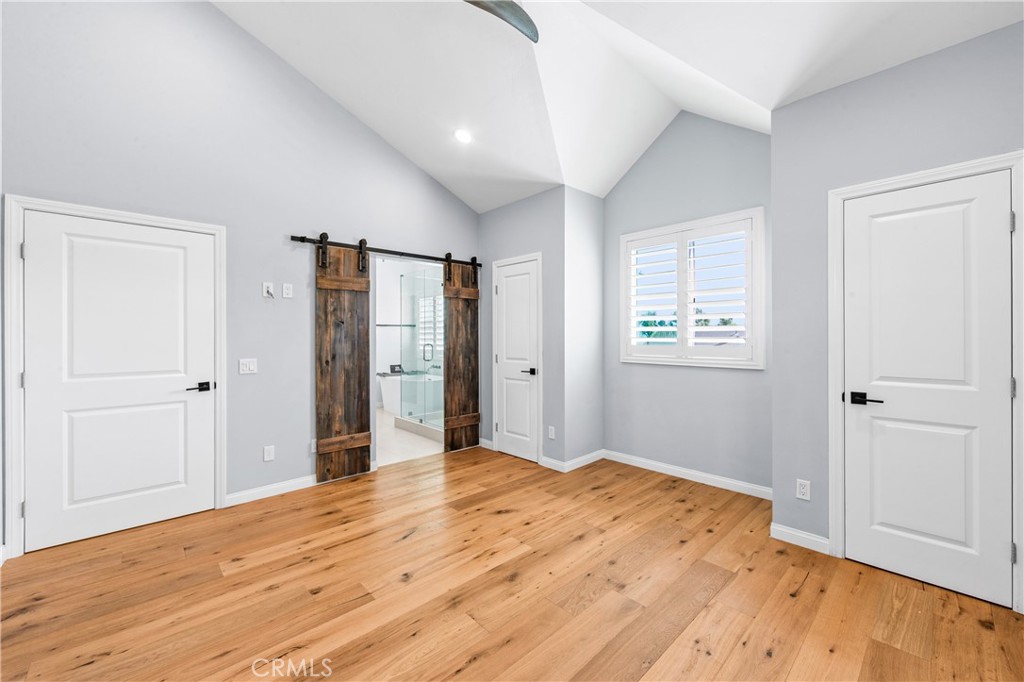 Spacious bedroom with warm wood flooring and abundant natural light. - 17327 Apel Lane, Huntington Beach CA 92649 - photo 29