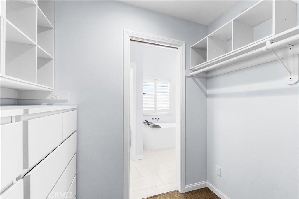 Custom-style walk-in closet with built-in shelving and organized storage. - 17327 Apel Lane, Huntington Beach CA 92649 - photo 34