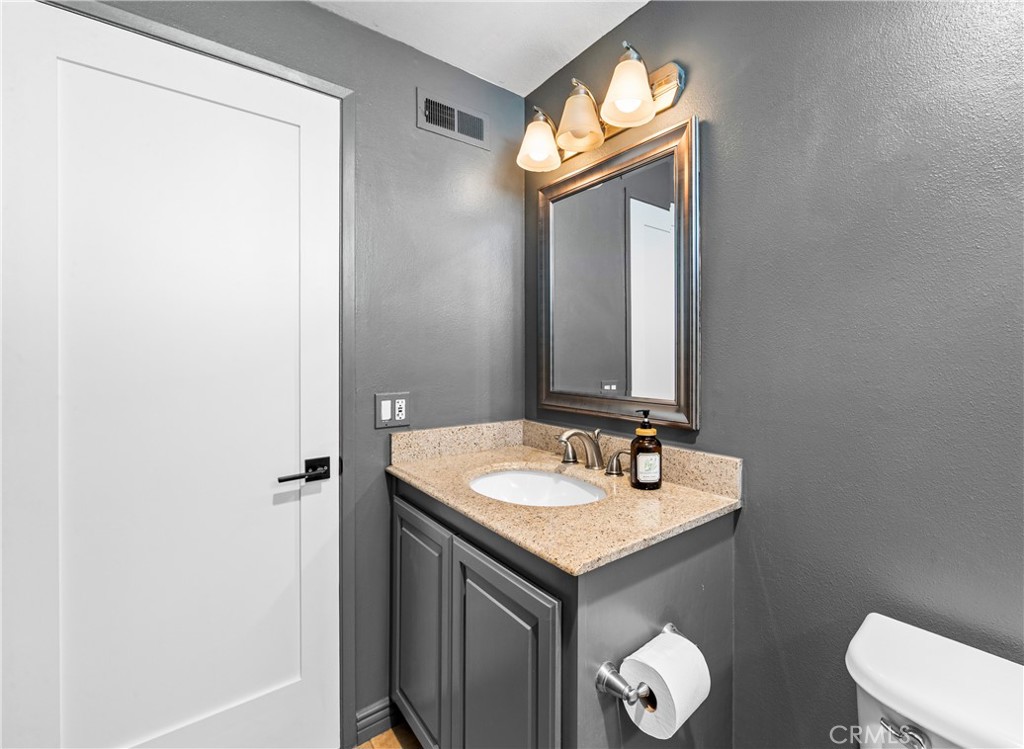 Elegant guest bathroom with sink vanity, modern finishes and ample storage. - 17327 Apel Lane, Huntington Beach CA 92649 - photo 38