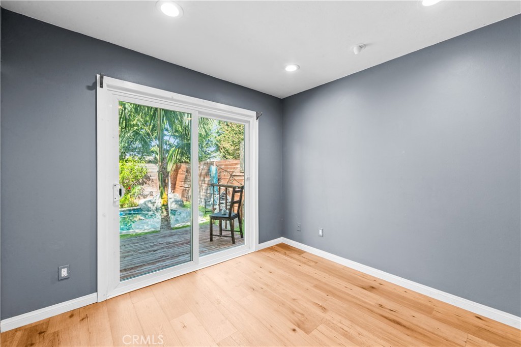 Spacious bedroom with French doors opening toward the home's outdoor living space. - 17327 Apel Lane, Huntington Beach CA 92649 - photo 42