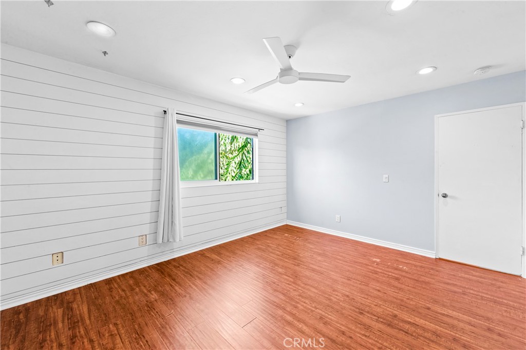 Bright bedroom with wood flooring, natural light and a clean contemporary finish. - 17327 Apel Lane, Huntington Beach CA 92649 - photo 47