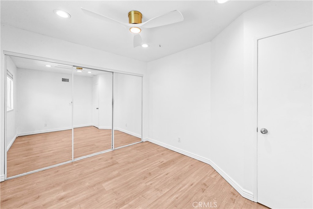 Bright bedroom with wood flooring, recessed lighting and ample closet space. - 17327 Apel Lane, Huntington Beach CA 92649 - photo 49