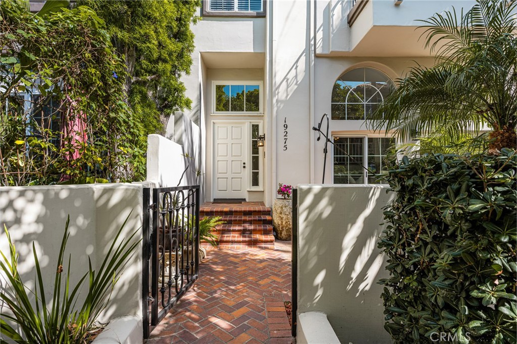 Gated courtyard entrance showcasing a stunning herringbone brick patio - 19275 Meadowood Circle, Huntington Beach CA 92648 - photo 1