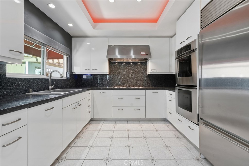 Kitchen with Sub-Zero refrigerator and Thermador stovetop and double ovens - 19481 Pompano Lane 112, Huntington Beach CA 92648 - photo 20