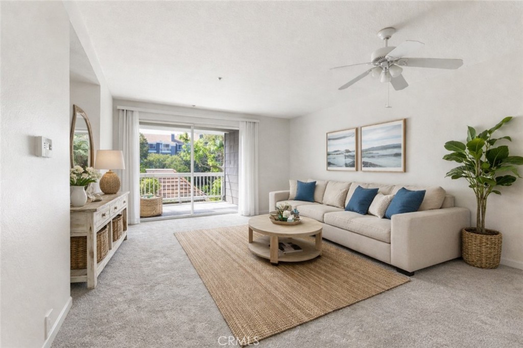Staged by AI. Beautiful light bright living room with lovely balcony overlooking grounds - 20301 Bluffside D-201, Huntington Beach CA 92646 - photo 1