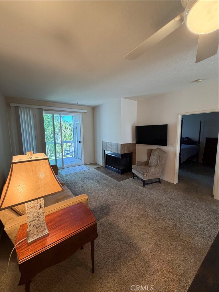 Living room with fireplace and access to balcony - 20331 Bluffside 309, Huntington Beach CA 92646 - photo 12