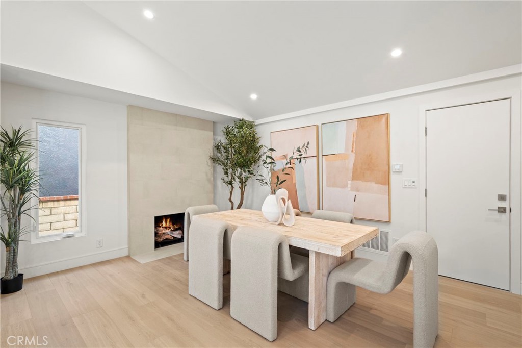 Elegant dining area is anchored by a striking designer-tiled fireplace and complemented by a custom buffet with wine ref - 20852 Farnsworth Lane, Huntington Beach CA 92646 - photo 14