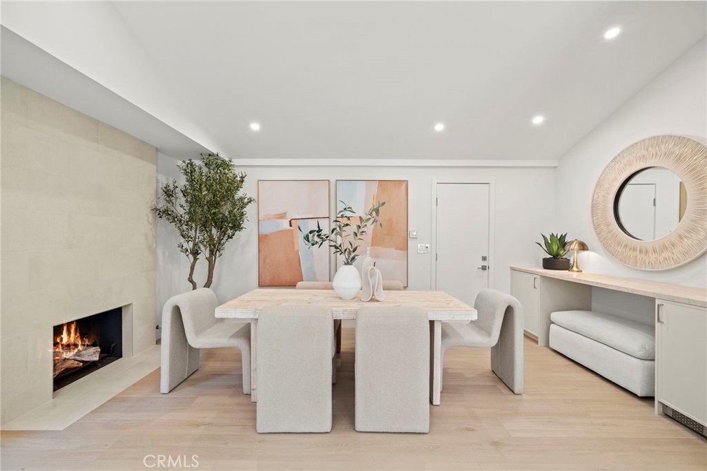 Elegant dining area is anchored by a striking designer-tiled fireplace and complemented by a custom buffet with wine ref - 20852 Farnsworth Lane, Huntington Beach CA 92646 - photo 17