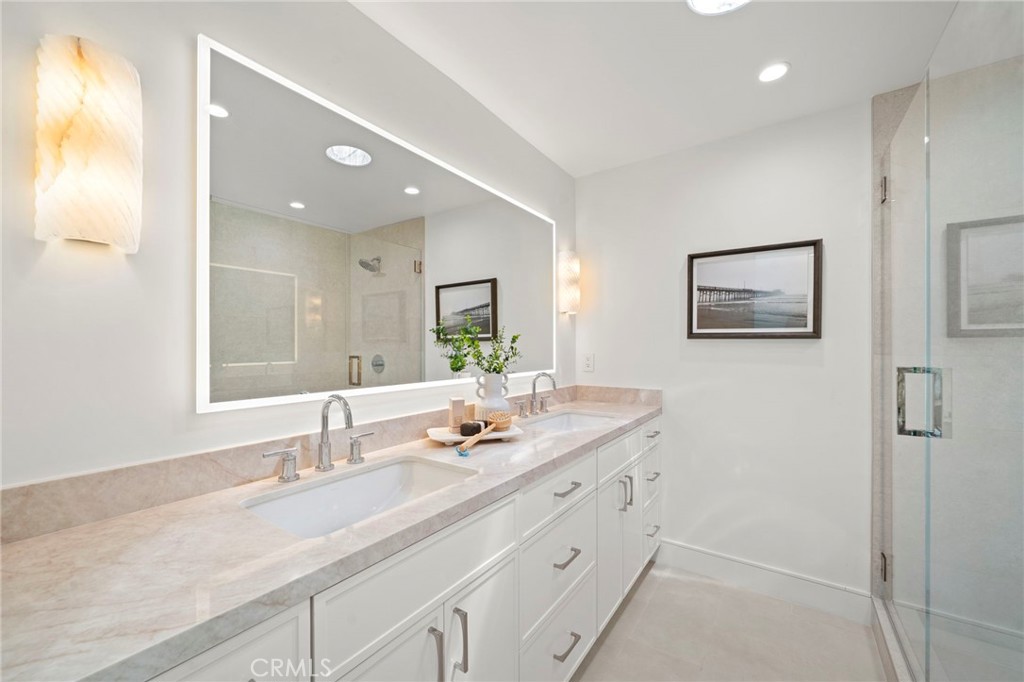 Spa-inspired primary suite bathroom with dual sinks, quartz countertops, custom cabinetry, sconce lighting, and oversize - 20852 Farnsworth Lane, Huntington Beach CA 92646 - photo 21