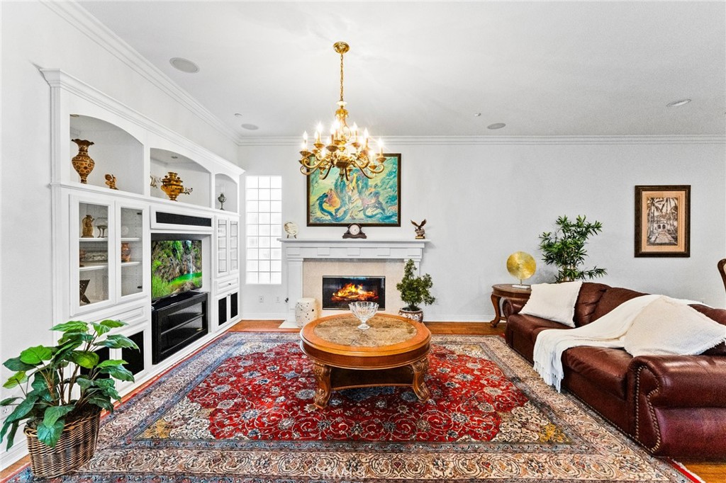 Custom built impressive entertainment center in the elegant living room with custom marble fireplace. - 21306 Balerma, Huntington Beach CA 92648 - photo 10