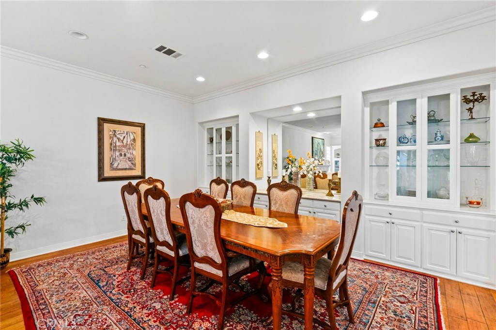 Gorgeous handcrafted custom built-in cabinetry with illuminated glass display panels in the banquet-sized formal dining - 21306 Balerma, Huntington Beach CA 92648 - photo 13