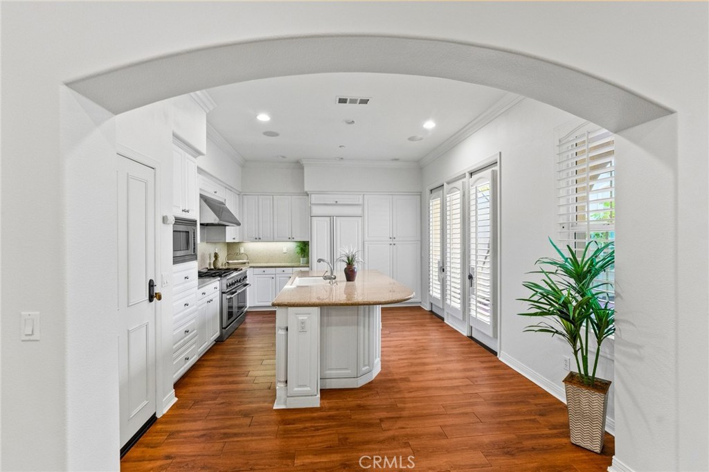The gourmet kitchen is a chef's dream, featuring a huge center island with wraparound seating, granite countertops, Ther - 21306 Balerma, Huntington Beach CA 92648 - photo 17