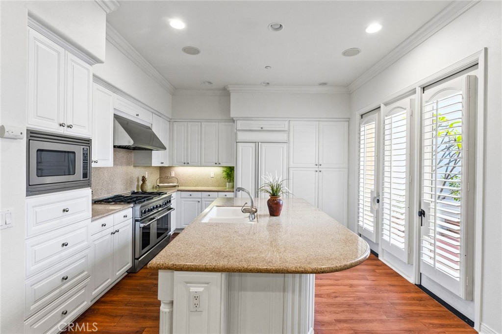Kitchen includes a professional 6-burner DCS range with double ovens including convection, microwave, dishwasher, and Su - 21306 Balerma, Huntington Beach CA 92648 - photo 18