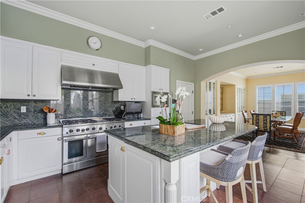 Kitchen with white cabinetry, large pantry with pull out drawers, granite counter tops and back splash, stainless steel - 21322 Balerma, Huntington Beach CA 92648 - photo 5