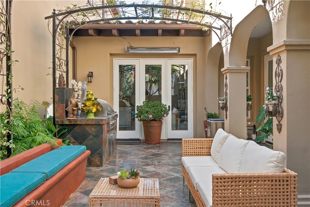 Enclosed courtyard with stone tile flooring, metal trellises with climbing vines, built in seating and custom-built outd - 21322 Balerma, Huntington Beach CA 92648 - photo 10