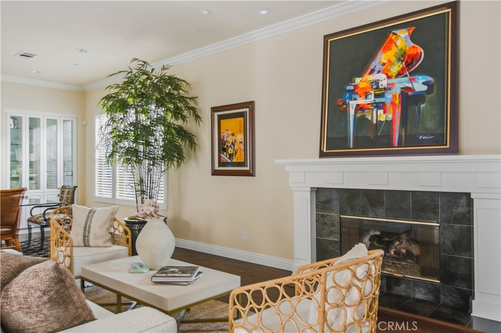 Living room with recessed lighting, crown molding, dark wood flooring, white fireplace, mantle and tile, large windows w - 21322 Balerma, Huntington Beach CA 92648 - photo 11